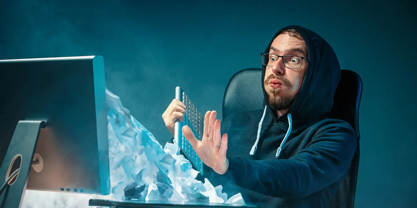 junger gestresster gutaussehender geschaeftsmann der am schreibtisch im modernen buero arbeitet und laptop bildschirm schreit und ueber spam wuetend ist