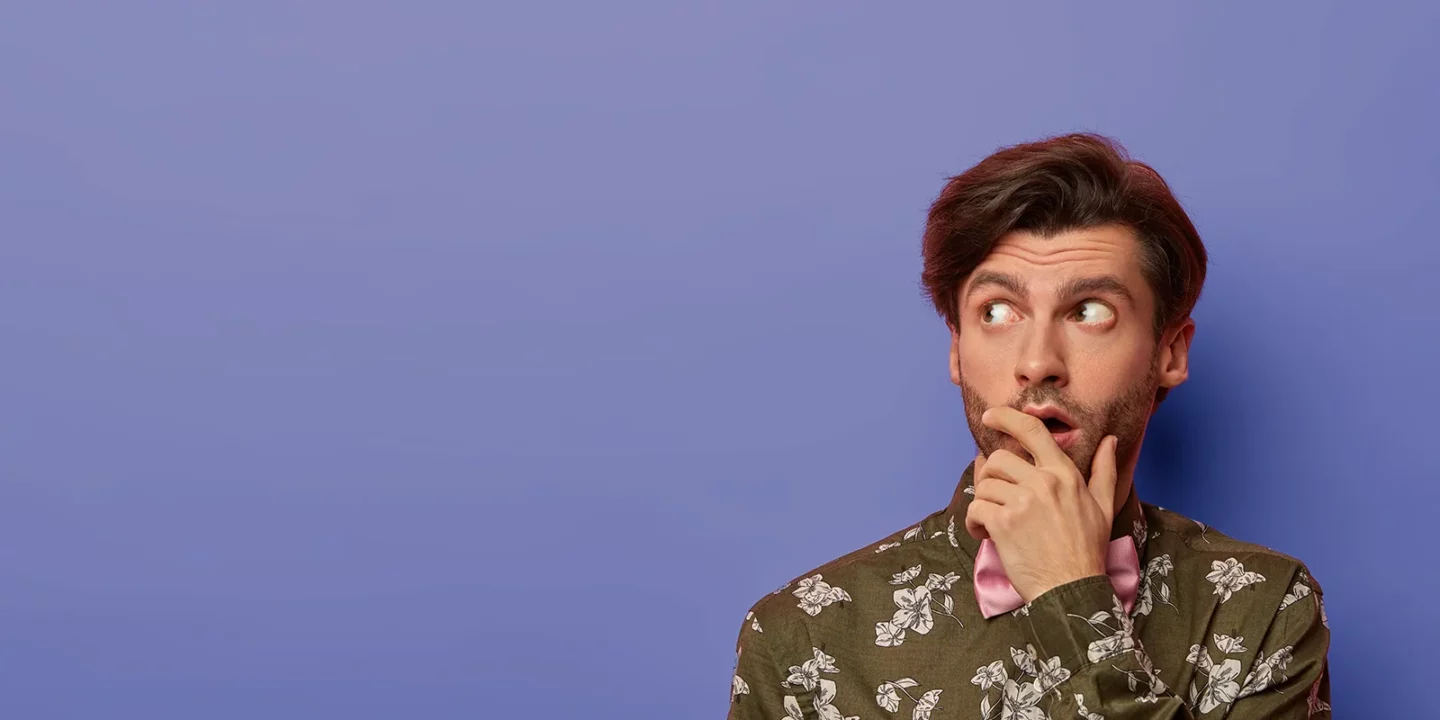 nachdenklich ueberraschter mann bedeckt den mund konzentriert beiseite denkt ueber schockierende relevanz nach gekleidet in ein hemd mit blumendruck